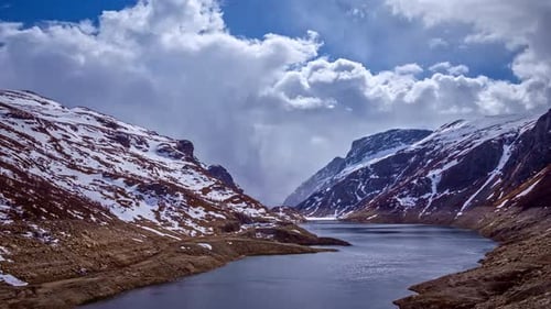 Timelapse of a river flowing between mountain hills with snow, norway landscape