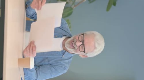 Senior Man Reviews Documents in Office