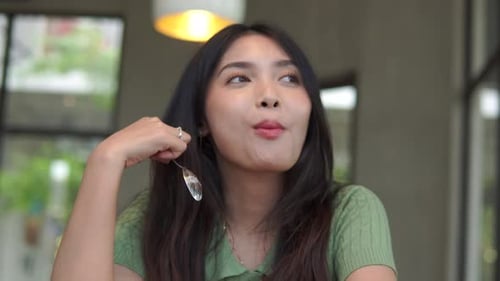 Woman Enjoys Cake in Cafe