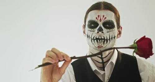 Man with Skull Makeup Holds Red Rose