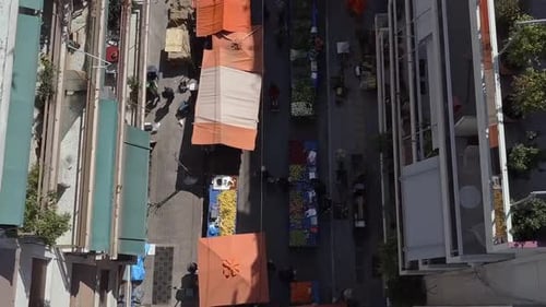 Aerial drone shot pulling away from busy street market Athens Greece