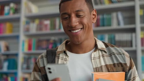Young Adult Student Using Smartphone in Library