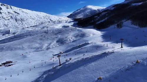 Skiers Carve Down Snowcovered Slopes Beneath a Brilliant Blue Sky in a Picturesque Mountain Resort