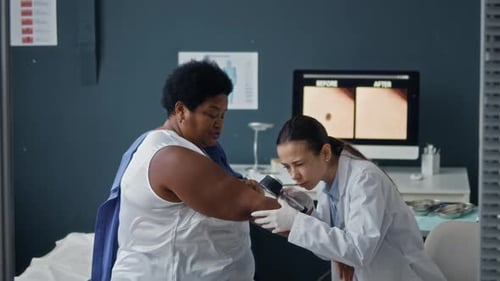 Doctor Examines Patient's Arm in Clinic with Magnifier