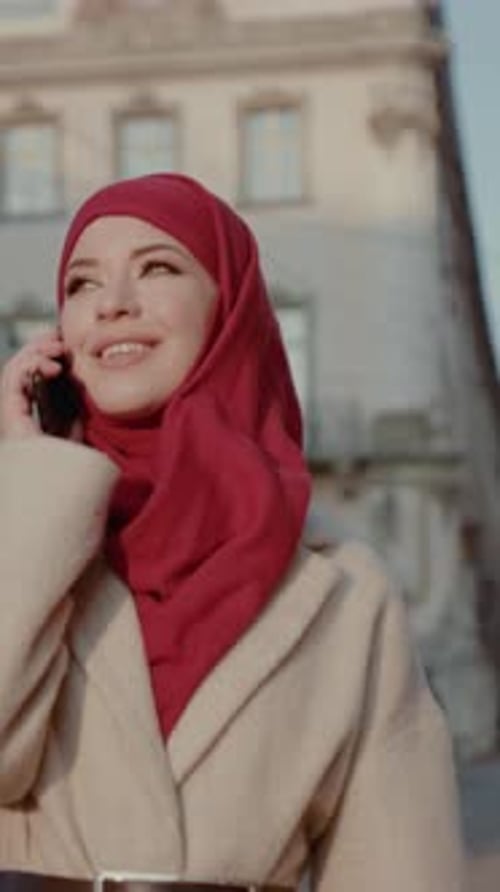 Eine modische junge Frau in einer städtischen Umgebung führt ein wichtiges Telefongespräch
