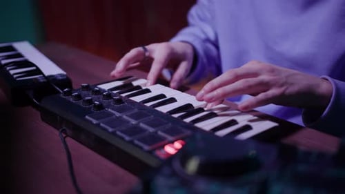 Person playing black and white keyboard in studio