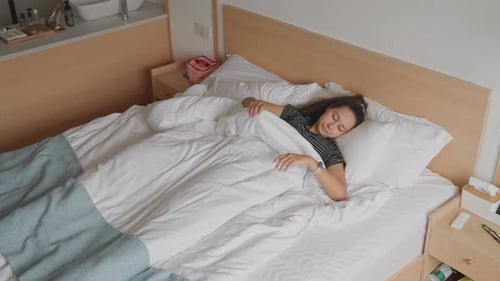 Woman Waking Up and Stretching in Bed
