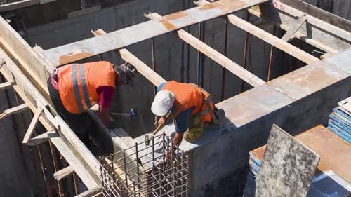 Luftaufnahme: Baustelle in vollem Gange — Arbeiter und Ausrüstung beim Materialtransport