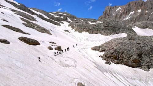 Eine Gruppe von Menschen wandert einen verschneiten Berg hinauf