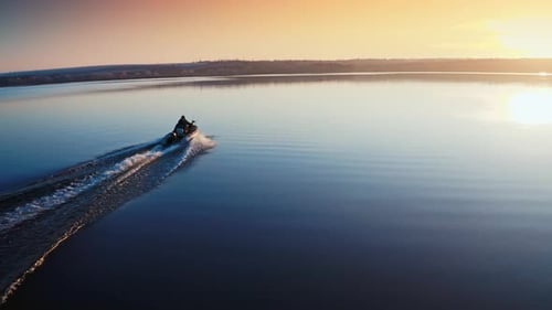 Boat on water surface at sunset.
