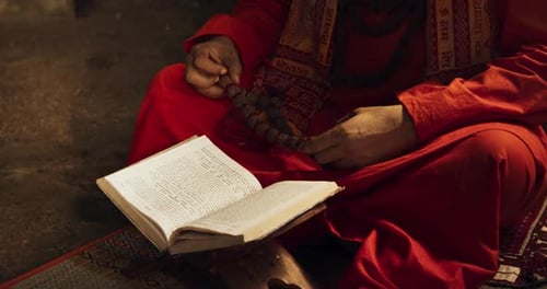 Slow Motion Portrait of Old Indian Monk Reading a Book in an Ancient Temple. Senior Guru G