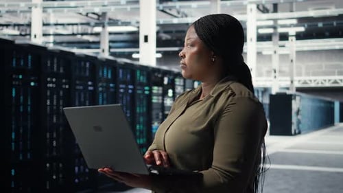 Programador em data center usando laptop para implantar nova arquitetura de servidor