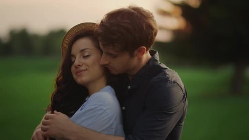 Closeup Sensual Couple Expressing Feelings on Meadow at Sunset. Handsome Man Hugging