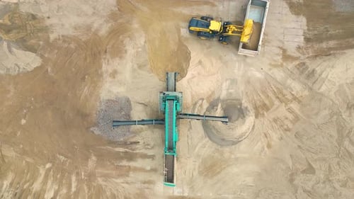 Wheel loader load sand in dump truck in open pit. Heavy machinery on developing opencast. Front end