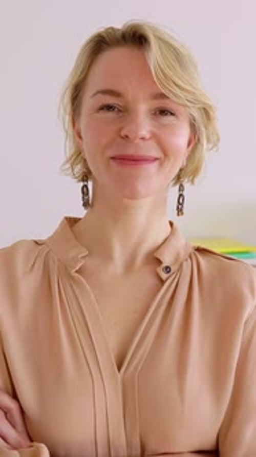 Portrait confiant d'une femme d'affaires d'âge moyen souriant à la caméra au bureau