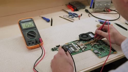 A Technician Man Hand Measuring Electrical Voltage of Computer Mainboard