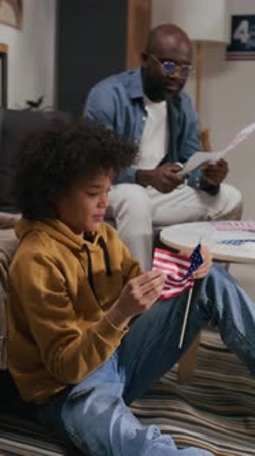 Boy with US Flag with Adult in Background