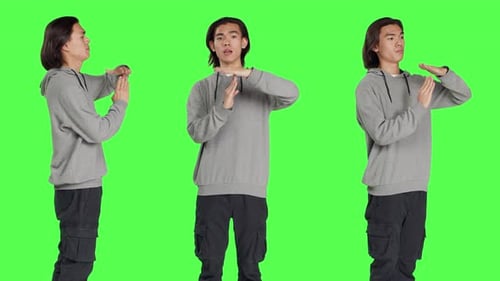 Young Adult Performs Time Out Gesture on Green Screen