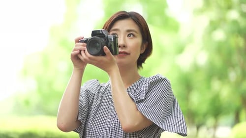 Woman Taking Pictures Outdoors With DSLR Camera