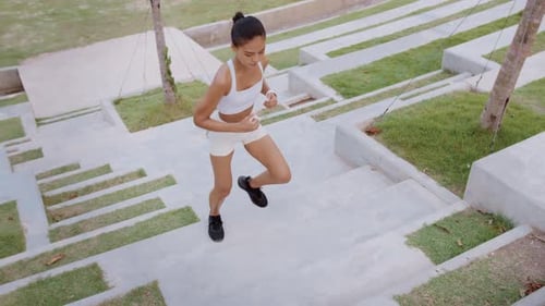Young fitness woman in sportswear exercising in city park