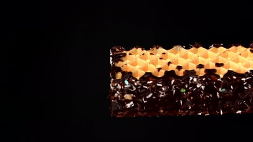 Close-up of a rotating wafer bar with marshmallow filling, sprinkled with coconut flakes. The rich a