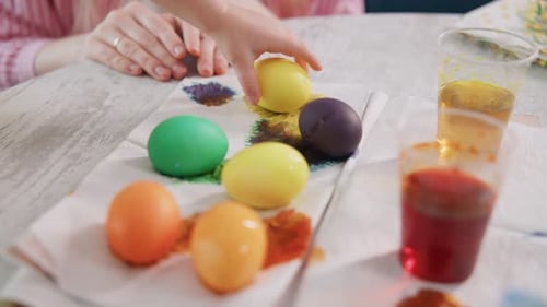 Small Hands Carefully Paint Eggs with Vibrant Dyes