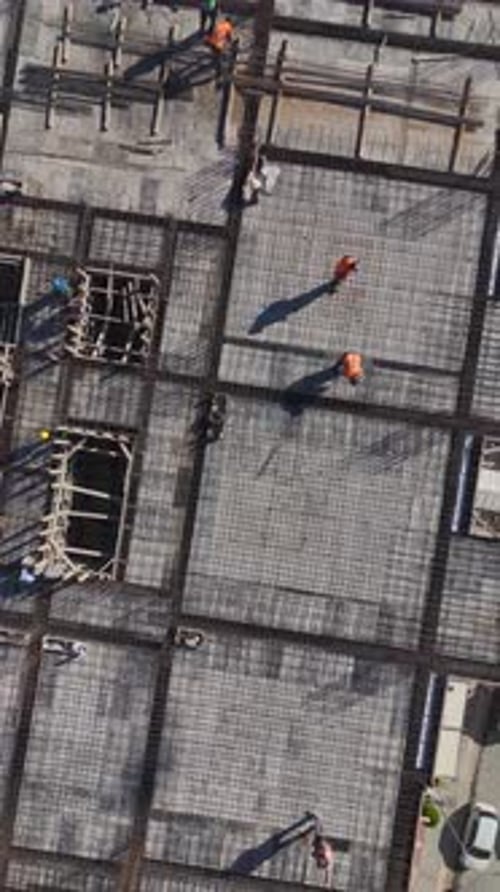Vídeo vertical de trabajadores instalando una estructura para pisos de concreto capturado verticalmente en un residencial