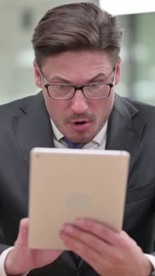 Middle Aged Businessman having Loss on Tablet, vertical video