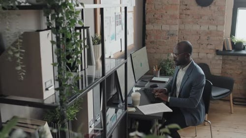 Man Works at Computer in Modern Office