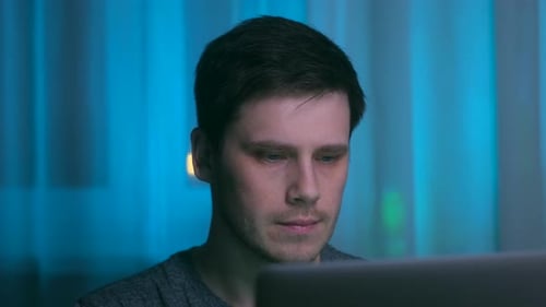 Mann arbeitet nachts am Laptop