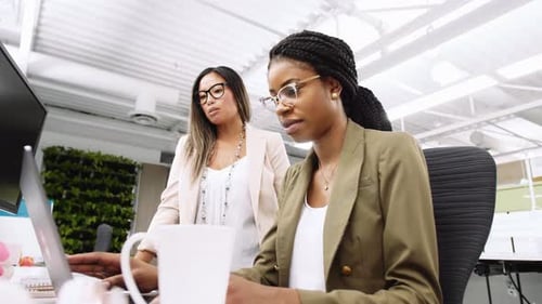 Close Up Of Colleagues Planning Work On Laptop In Office
