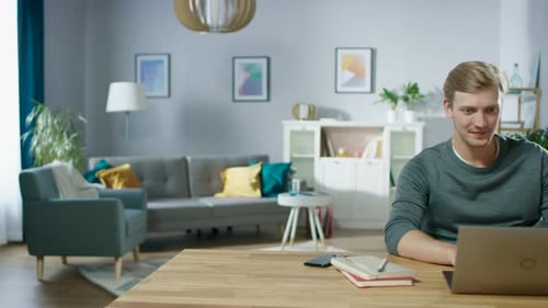 Young Adult Works on Laptop at Home