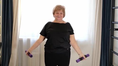 Una mujer mayor que levanta pesas durante un entrenamiento destaca la aptitud física, la movilidad y el mantenimiento