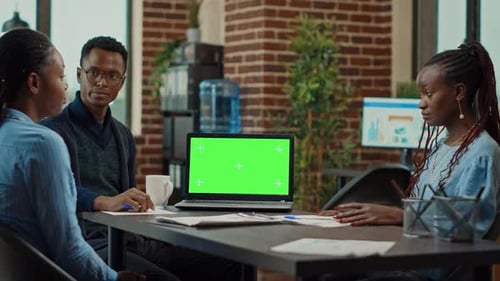 Colleagues at Meeting with Green Screen Laptop