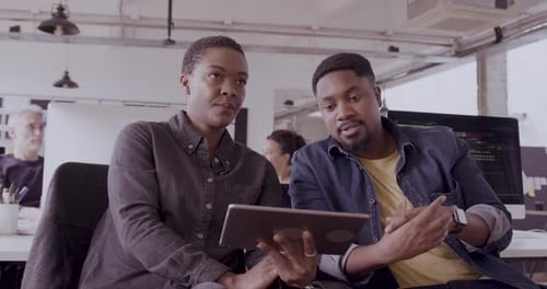 Two Colleagues Working Together in Bright Office