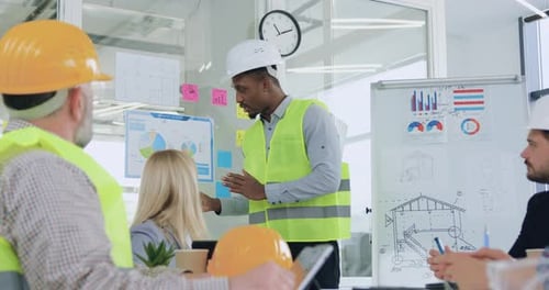 African american man engineer explaining round diagram during meeting in office with engineer team