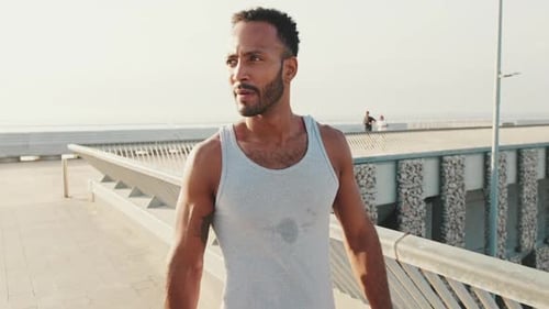 Young fit athlete walks after training on the embankment