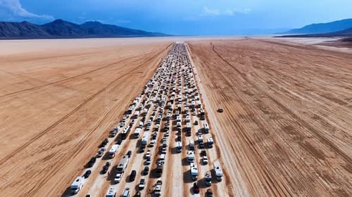 Endless Line of Cars and RVs on Arid Desert Playa.