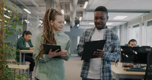 Businesspeople Walking in Open Space Office Talking Using Tablet and Reading Document