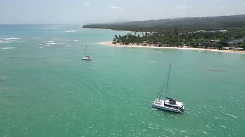 Luxurious catamarans in the turquoise waters at Punta Popy beach in Las Terrenas on the caribbean is