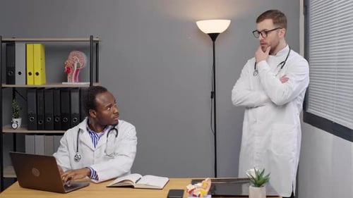 Doctors Consulting on Laptop in Modern Office