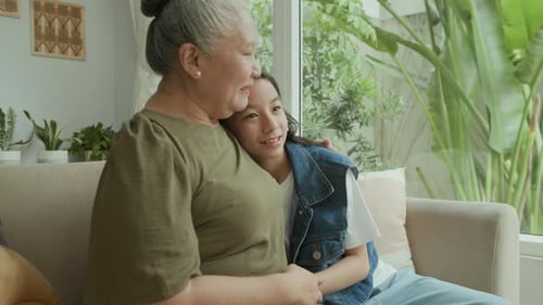 Grandmother and Granddaughter Holding Hands on Sofa