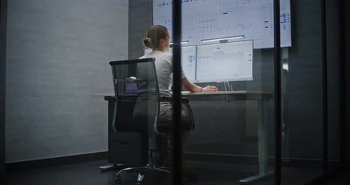 Börsenmaklerin beobachtet Börsendiagramme auf dem MultiMonitor-Desktop-Setup im Büro