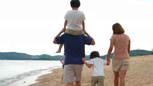 Happy asian family walking outside on the beach together having fun enjoy freedom