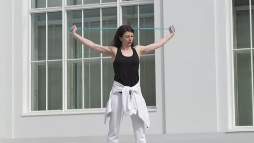 Woman Exercising with Resistance Band in Urban Setting