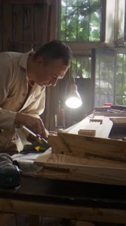 Senior Man Corrects Door Frame Corner with Sharp Chisel Slowly