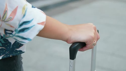 Female Hand Holding Suitcase Handle. Close Up Tourist Woman Walking with Travel