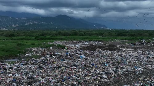 Aerial view of city garbage dump on background of sea. Dump near resort town on seashore in Batumi,