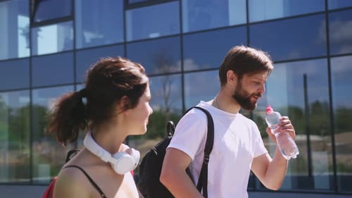 Close Up of Happy Joyful People Walking Together After Sport Fitness and Drinking Water From Bottle