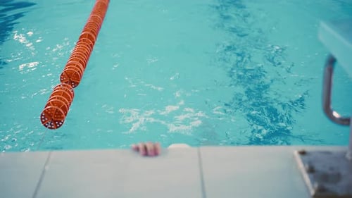 Swimmer Rests After Swimming Laps in Pool